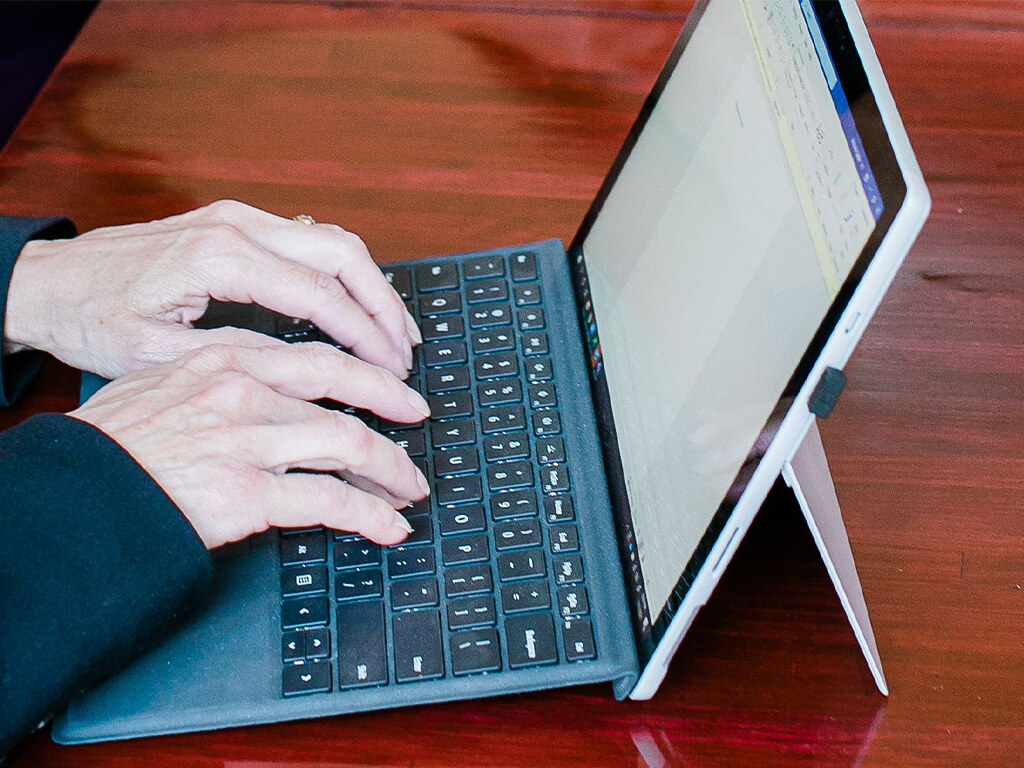 Hands typing on a laptop